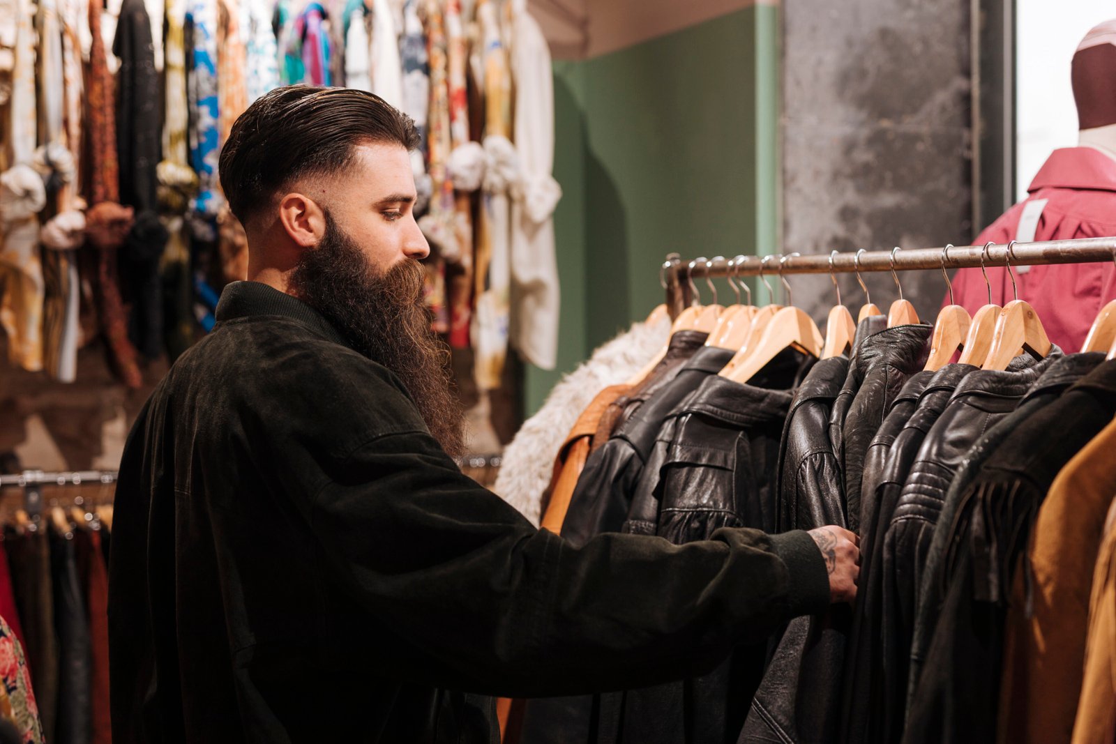 close-up-man-looking-leather-jacket-rail-clothing-shop